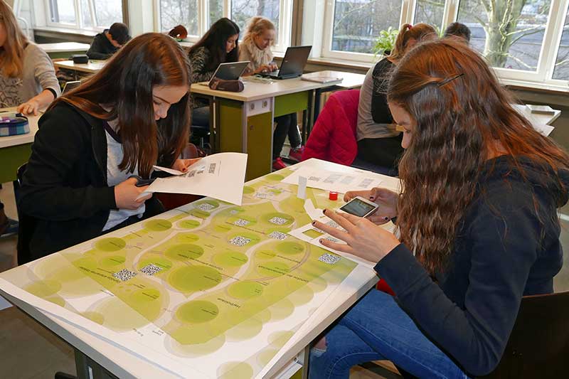 Schüler ordnen QR-Codes den Bäumen im Baumpark Pinneberg zu